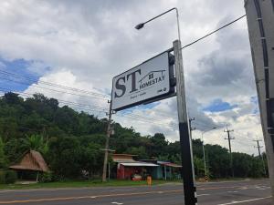 a street sign on the side of a road at เอส ที โฮมสเตย์ นครนายก in Ban Hin Dat
