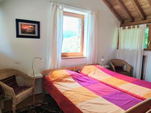 a bedroom with a bed and two chairs and a window at La Bastide en Cévennes in Saint-Hilaire-de-Lavit