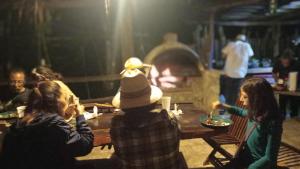 a group of people sitting around a table in front of a fireplace at Camping Rancho El Tauro in Macario Gomez +1 photo