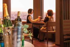 a group of three women sitting at a table with wine glasses at ANA Holiday Inn Kanazawa Sky by IHG in Kanazawa
