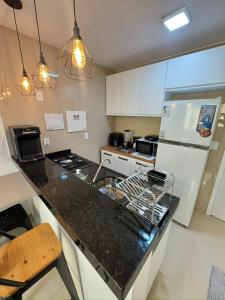 a kitchen with a white refrigerator and a counter top at Ap próx ao shopping com garagem, piscina e ar in Sobral +45 photos