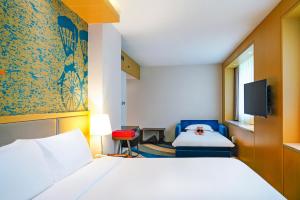 a hotel room with a bed and a tv at Radisson Collection Hyland Shanghai in Shanghai