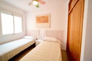 a bedroom with two beds and a window at Soleado adosado esquinero frente a piscina in Gran Alacant +31 photos