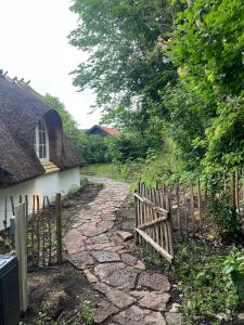 a fence next to a path next to a house at Peace In Beautifully Renovated Country House in Ålsgårde +9 photos
