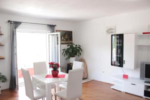 a dining room with a white table and white chairs at Apartments Ustavdic in Korčula