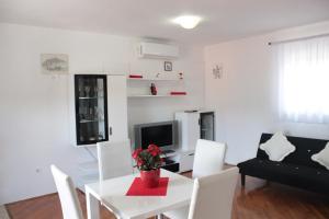 a living room with a white table and white chairs at Apartments Ustavdic in Korčula