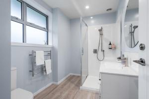 ein weißes Badezimmer mit Dusche und Waschbecken in der Unterkunft Beach Road Oasis - Waikawa Holiday Home in Picton + 25 Fotos