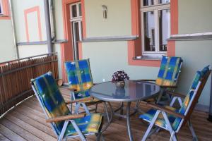 a table and four chairs on a balcony at Apartment Am Markt 16, Bandusch-Szemák in Pirna