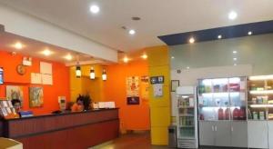 成都7 Days Inn Chengdu North Railway Metro Station的一间拥有橙色墙壁和柜台的餐厅