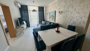 サニービーチにあるTurtle Apartment Sunny Beachのリビングルーム(テーブル、青い椅子付)