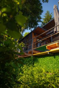 a house with a deck on a hill with trees at SteLar Lake View 2025 in Teşila