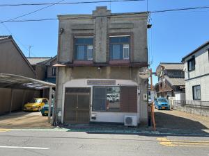 a building with a sign on the side of a street at 犬山口ゲストハウス in Wada