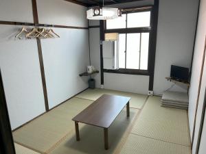 a living room with a table and a window at 犬山口ゲストハウス in Wada