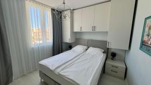 サニービーチにあるTurtle Apartment Sunny Beachのベッドルーム(白いベッド1台、白いキャビネット付)