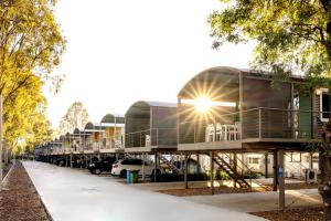 a building with a lot of cars parked in a parking lot at BIG4 Deniliquin Holiday Park in Deniliquin