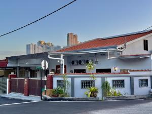 un edificio bianco con piante di fronte a una strada di Spacious 2 Storey Homestay Tanjung Bungah 25Pax by 3C a Tanjung Bungah