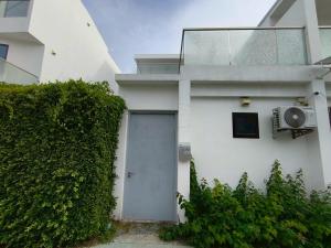 a white house with a door and a hedge at TYb04 芭提雅北歐風格四臥室別墅 in Pattaya South