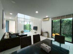 a living room with a couch and a glass table at TYb04 芭提雅北歐風格四臥室別墅 in Pattaya South