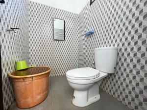 a bathroom with a toilet and a bucket at MP Villa Orchard D1 Malang in Malang +43 photos