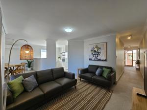 a living room with a couch and a table at Pelican Shore Villa 12 - Kalbarri WA in Kalbarri