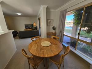 a dining room with a wooden table and chairs at Pelican Shore Villa 12 - Kalbarri WA in Kalbarri