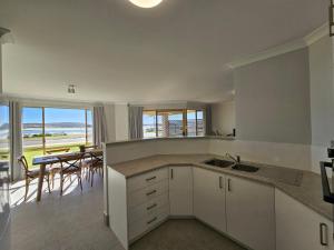 カルバリにあるPelican Shore Villa 1- Kalbarri WAのキッチン(シンク、眺めの良いテーブル付)