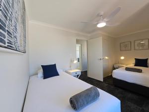 a bedroom with two beds and a ceiling fan at Pelican Shore Villa 11- Kalbarri WA in Kalbarri