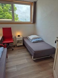 ein Schlafzimmer mit einem Bett und einem roten Stuhl in der Unterkunft Thise Ladegaard in Manna + 53 Fotos