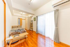 那覇市にあるCasa Leo ASATO カサレオ安里の部屋にベッドとテーブルがある寝室