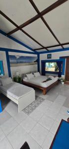two beds in a room with blue walls at Omah Alchy Cottages in Karimunjawa