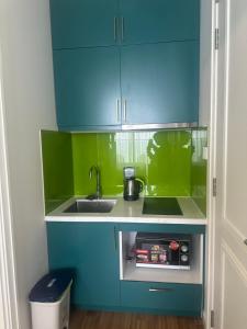 a small kitchen with a sink and blue cabinets at Vy hillside the apartment sunset town city in Phu Quoc