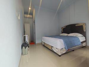 a bedroom with a bed in a white room at Cherry Homestay in Kuta Lombok