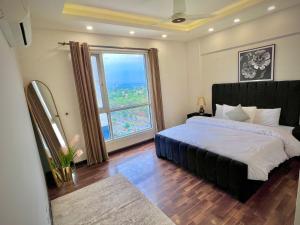 イスラマバードにあるElysium Sky-High Executive Apartments Luxury Stay Facing Centaurus Mall Islamabadのベッドと大きな窓のある寝室 +52枚の写真