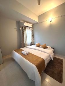 a bedroom with a large bed with two towels on it at The Dan Si in Guwahati