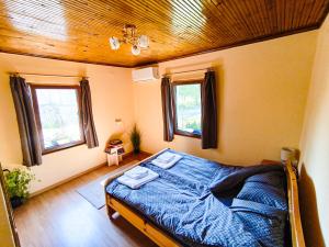 a bedroom with a bed with a wooden ceiling at Вила Хармония Harmony Cottage in Kyustendil