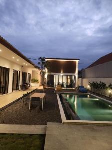 a house with a swimming pool in front of a house at Bali Thousand Island Living in Pesanggaran