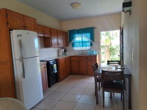a kitchen with a white refrigerator and a table with chairs at Etinoff's Apartments in Sutherlands Development