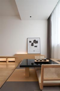 a living room with a table and a couch at SFEEL设计师酒店Designer Hotel成都杜甫chao堂店 in Chengdu