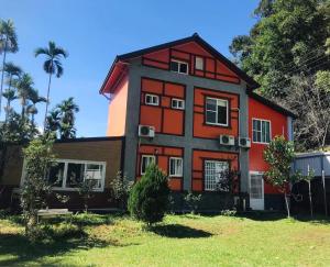 een rood en zwart huis met een palmboom bij Clover B&B in Yuchi +18 foto's