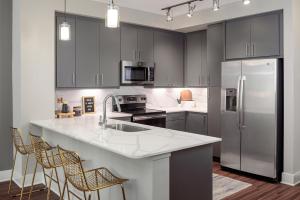 a kitchen with stainless steel appliances and a white counter top at AMLI Addison in Addison