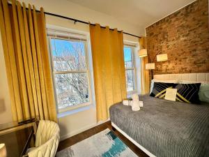 a bedroom with yellow curtains and a bed and a window at Hotel-Style, No Host, Professionally Managed ID289 in Jersey City