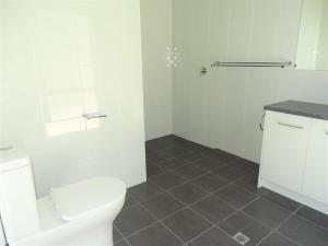 a white bathroom with a toilet and a shower at Henri's Place in Wauraltee