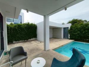 una casa con piscina y silla en TYb03 芭提雅北歐風格三臥室別墅, en Pattaya South