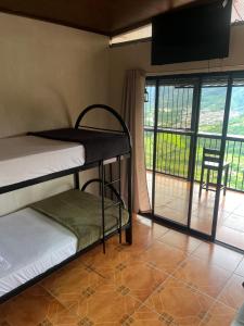 a room with two bunk beds and a balcony at Cabaña Vista al Valle in Paraíso