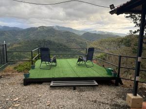 two chairs on a table with a view of mountains at Cabaña Vista al Valle in Paraíso +1 photo