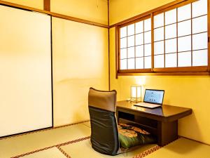 a room with a desk with a laptop on it at The M OTAMACHI in Nakatsugawa