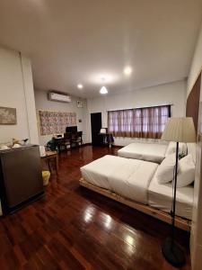 a bedroom with a large bed and a living room at INCM Guesthouse in Chiang Mai