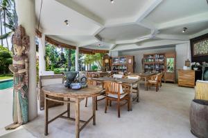 a dining room with wooden tables and chairs at The Village of Angels in Manggis