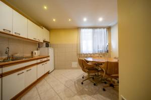 a small kitchen with a table and a sink and a refrigerator at Pokoje u Beaty in Zakopane