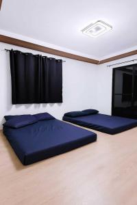 two beds in a room with black curtains at The Hidden Escape in Sampong +17 photos